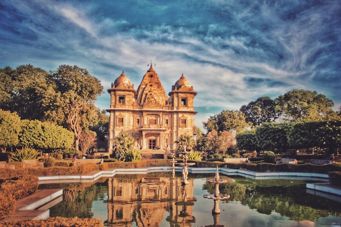 Photo by Suryansh Raghuvanshi Brown Concrete Building Near Fountain Under Blue and Gray Sky
